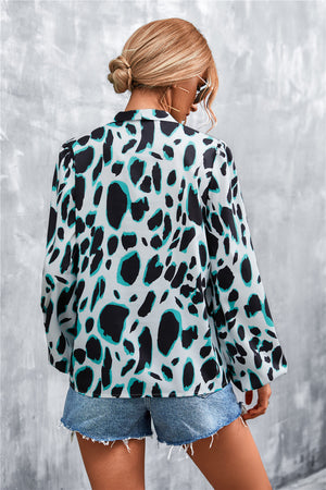 Women's abstract print blouse with balloon sleeves and a pussy bow neckline, in a black and teal animal print.
