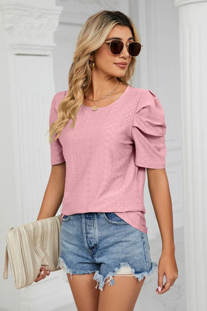 Pink perforated sleeve blouse with a round neckline and puff sleeves.