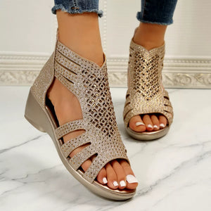 Gold cutout ankle cuff wedge sandals with rhinestone embellishments and a zipper closure.