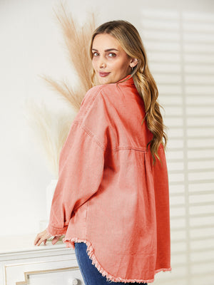Orange-red distressed denim overshirt with raw hem and buttoned front.