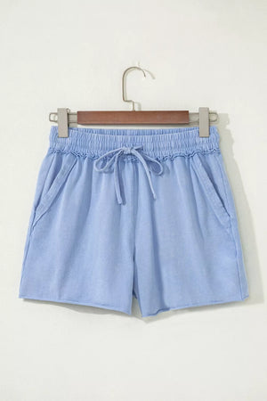 Light blue acid-washed cotton drawstring shorts with pockets and raw hem