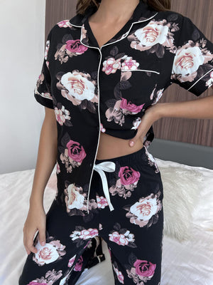 Floral print pajama set with contrast trim, featuring a buttoned top and drawstring pants.