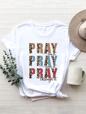 White graphic t-shirt with "PRAY on it PRAY over it PRAY through it" text in leopard print and solid colors.