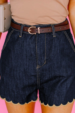 Dark blue denim shorts with scalloped hem and contrast stitching.