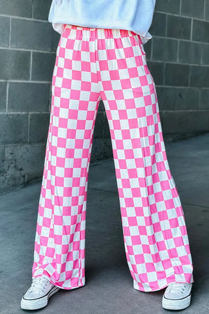 Checkerboard palazzo trousers in fuchsia pink and white, with a wide leg and elastic waist.