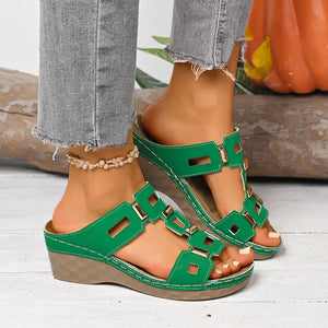 Green open-toe wedge sandals with gold hardware and cut-out details.