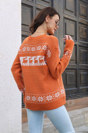 Orange reindeer jacquard knit sweater with snowflake pattern and crew neck.