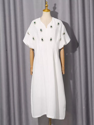 White midi dress with puff sleeves and scattered green rhinestone embellishments.
