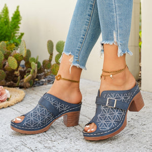 Blue block heel sandals with white floral embroidery and buckle detail.