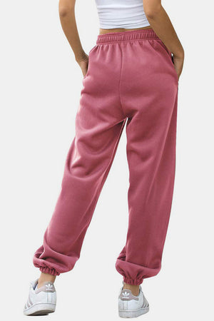 Dusty pink sweatpants with gathered cuffs and elastic waistband, shown from the back.