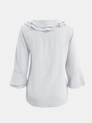 White linen blouse with ruffled neckline and flared 3/4 sleeves.