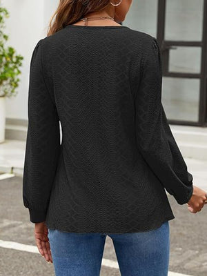 Black perforated puff sleeve blouse with textured fabric and balloon sleeves.