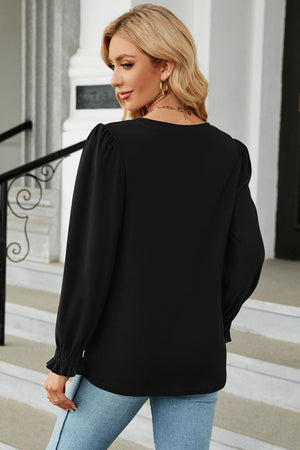 Black ribbed cuff top with puff sleeves and ruffled cuffs.