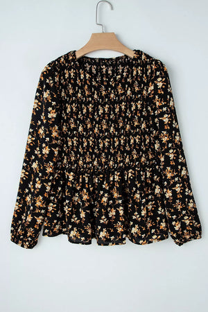 Black floral long-sleeve blouse with smocked waist and peplum hem.
