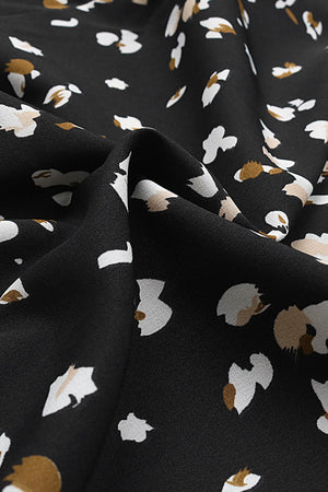 Black midi wrap dress with abstract floral print and button front detail.