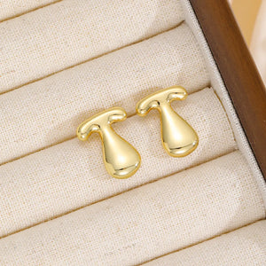 Gold sculpted stud earrings with a bubble-like alphabet design.