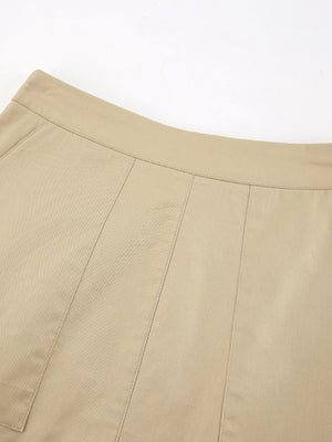 High-waisted beige cotton A-line skirt with pockets and stitched panel details.
