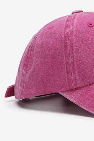 Washed cotton baseball cap in magenta with adjustable strap detail.