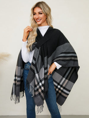 Black plaid fringe cape with asymmetric design and herringbone detail.