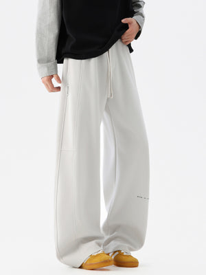 Light gray casual drawstring pants with a relaxed fit and subtle text detail.
