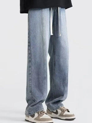 Men's blue oversized fit jeans with drawstring and seam detail.