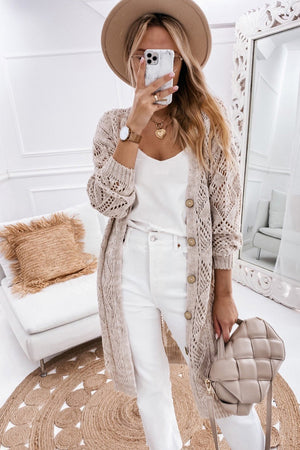 Tan openwork button-down maxi cardigan with wooden buttons, styled with white jeans.