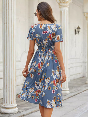 Blue gray midi dress with vibrant floral pattern, short sleeves, and cinched waist.