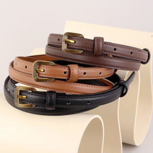 Sleek cowhide leather accent belts in brown, black, and caramel with antique brass buckles.