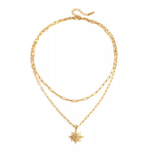 Layered gold necklace with sun pendant and crystal details