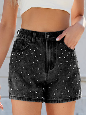 Black studded denim high-waisted cutoff shorts with a distressed hem.