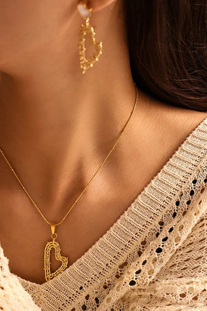 Gold woven heart pendant necklace and matching earrings with pearl detail.