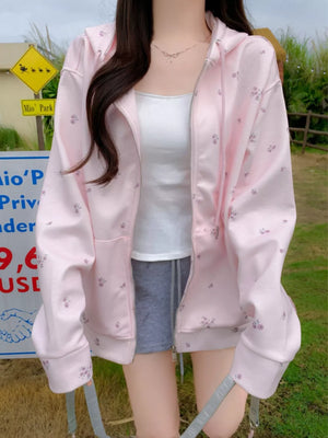 Pink floral zip-up hoodie with drawstring and white tank top.