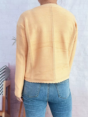 Yellow button up cardigan with scalloped hem and textured seams.