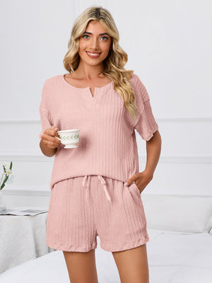 Blush pink ribbed knit pajama set with V-neck top and drawstring shorts.