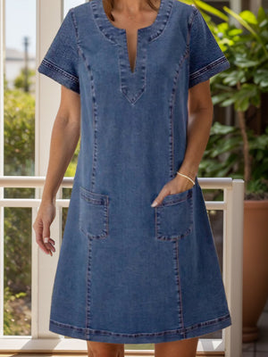 Denim trapeze dress in dusty blue with V-neck and patch pockets.
