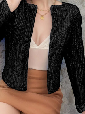 Black sequin bolero jacket with long sleeves and open front, worn over a white camisole.