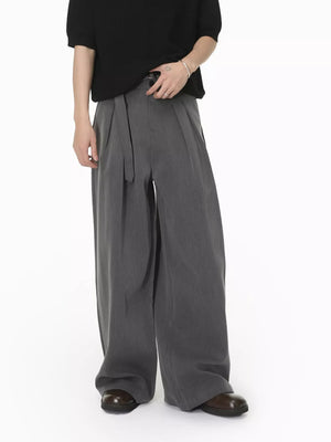 Grey wide-leg pleated sweatpants with a belted waist.
