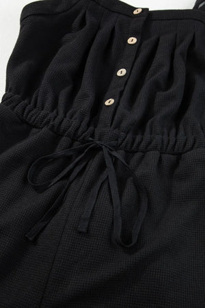 Black waffle knit jumpsuit with drawstring waist and button front detail