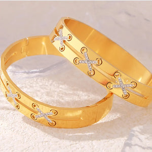 Gold cuff bracelet with diamond criss-cross detail and eyelet accents