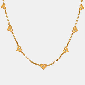 Gold chain necklace with scattered heart charms, each with a small zirconia stone.