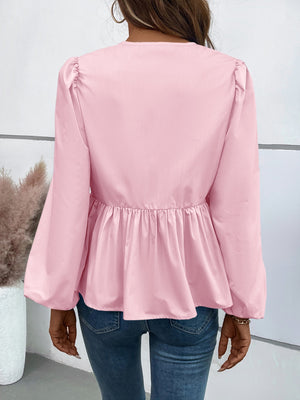 Blush pink peplum blouse with gathered shoulders and long balloon sleeves.