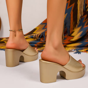 Gold open-toe block heel platform sandals with textured straps and an anklet.