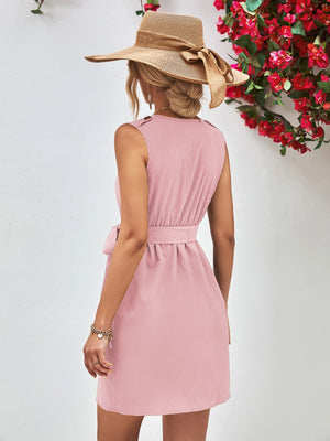 Button-down tie-waist sleeveless shirtdress in blush pink with textured fabric and a belted waist.