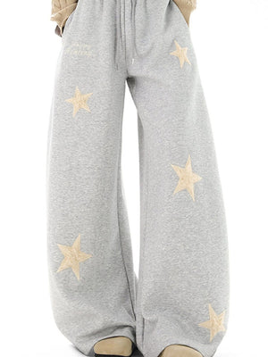 Gray wide leg sweatpants with drawstring and embroidered stars.