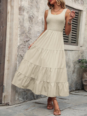 Beige smocked bodice tiered maxi dress with square neckline and sleeveless design.
