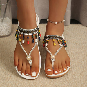 Bohemian beaded ankle strap sandals in white with colorful beads and pearl detail.