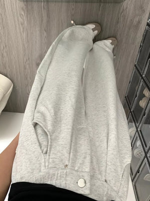 Gray wide-leg sweatpants with adjustable drawstring and snap details.