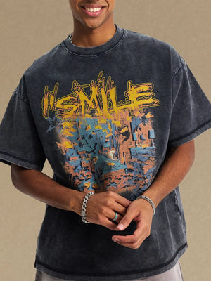 Washed black oversized graphic tee with abstract yellow, blue, and orange print.
