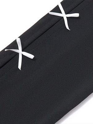 Black mini dress with white bowknot details and contrast stitching.