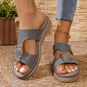 Gray open-toe sandals with decorative buckle detail and wedge heel.